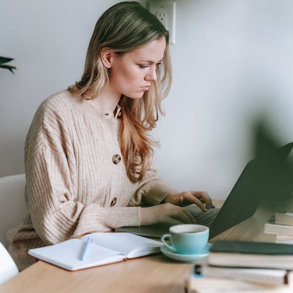 A modern workspace with a laptop, a cup of coffee, and a daily planner.